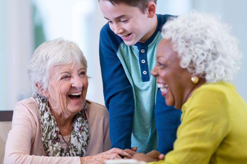 two women laughing with grandson